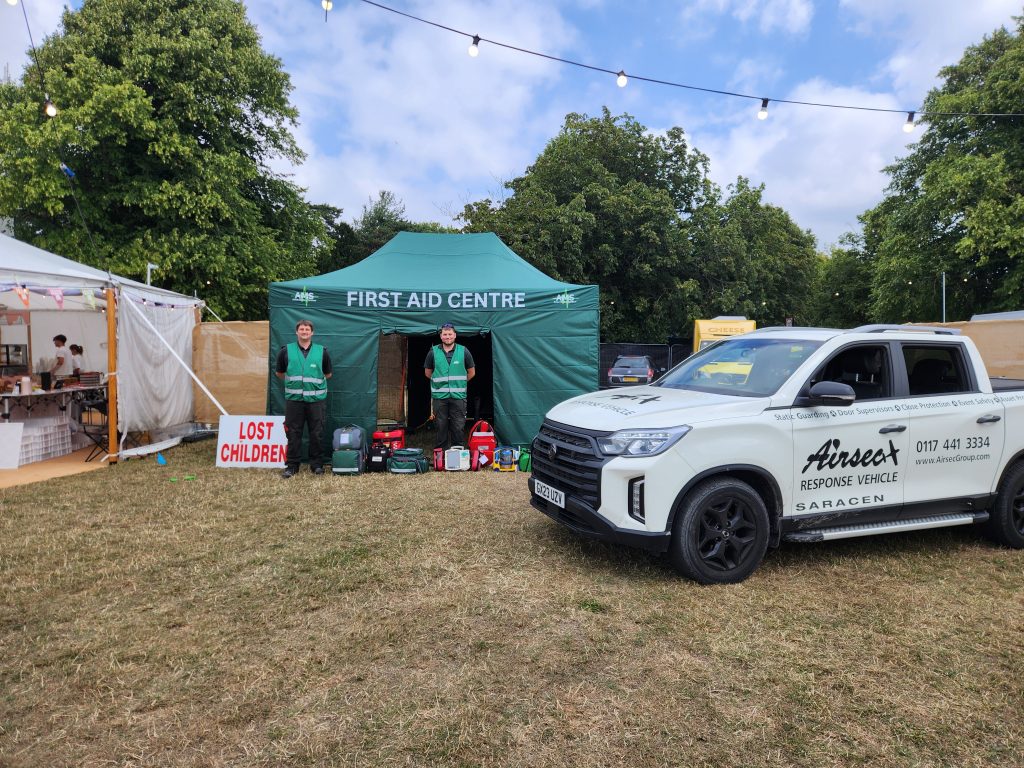 First Aid Centre tent with staff and a response vehicle at an outdoor event.